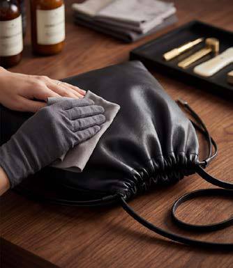 Pulizia di una borsa in vera pelle liscia con panno morbido